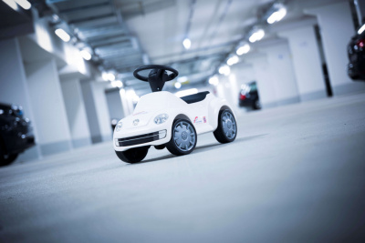 Weißes Bobbycar in einer Tiefgarage