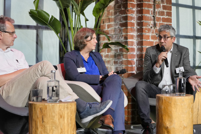 Plenumsdiskussion auf dem Mobilitätskongress mit drei Männern und einer Frau.