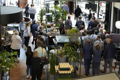 Blick von oben auf die Cateringfläche im Lokschuppen Marburg. Viele Menschen stehen am Buffet an.